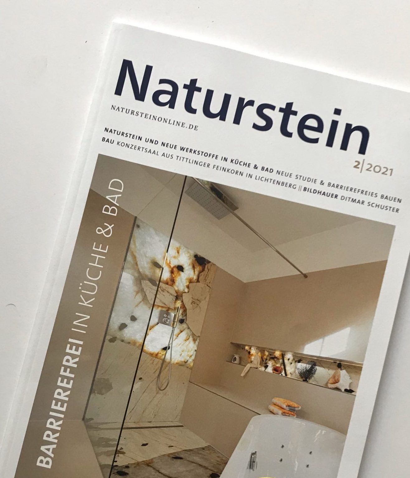 Titel der Zeitschrift Naturstein zeigt eine schwellenloses Dusche mit einer Lichtdurchleuchteten Fläche.